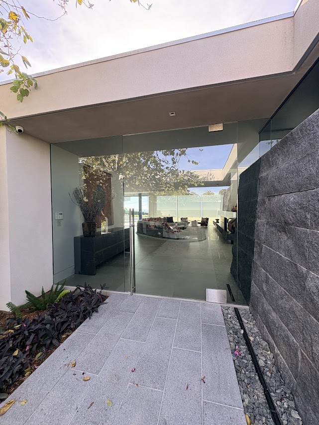 Modern glass entrance with view inside home.